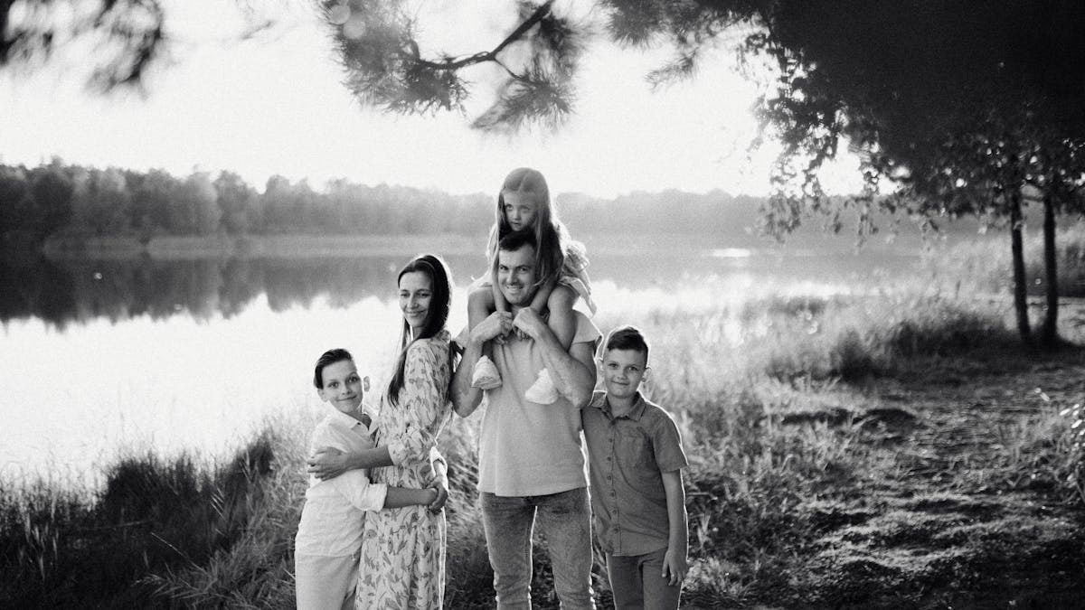 A joyful family enjoying time by the lake in a serene setting.